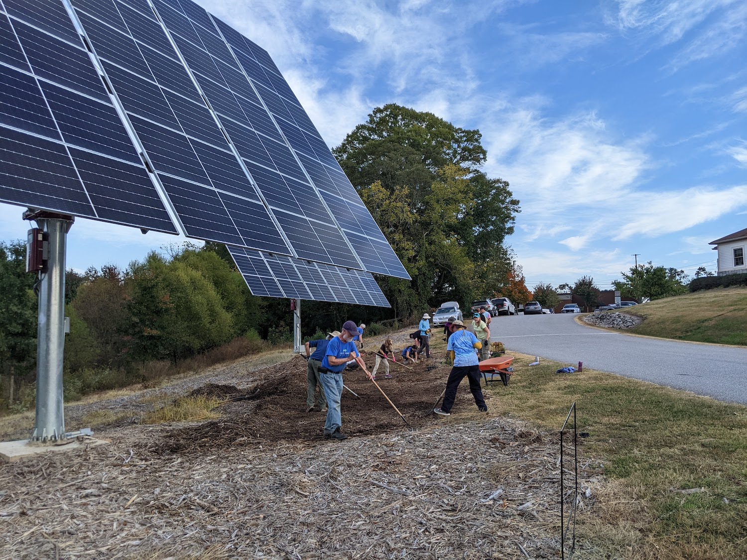 Group working on landscaping beneath solar panels